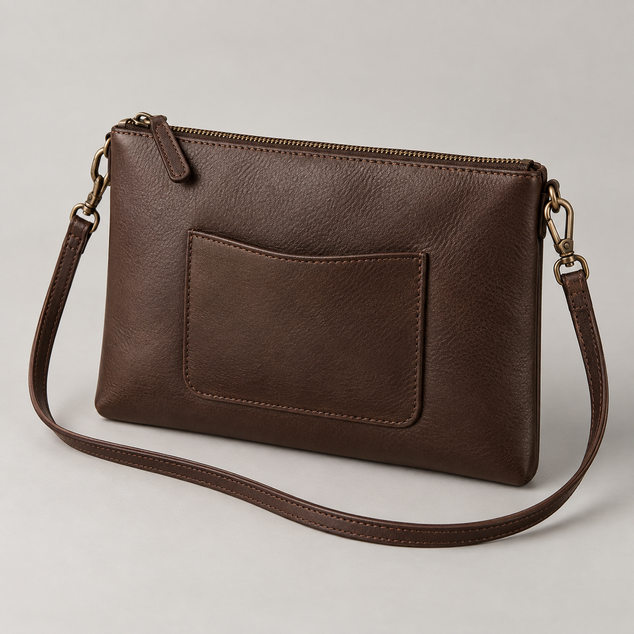 Espresso Pouch: Flat zip pouch silhouette with a detachable narrow strap and a small external pocket. Illustrative design reference.