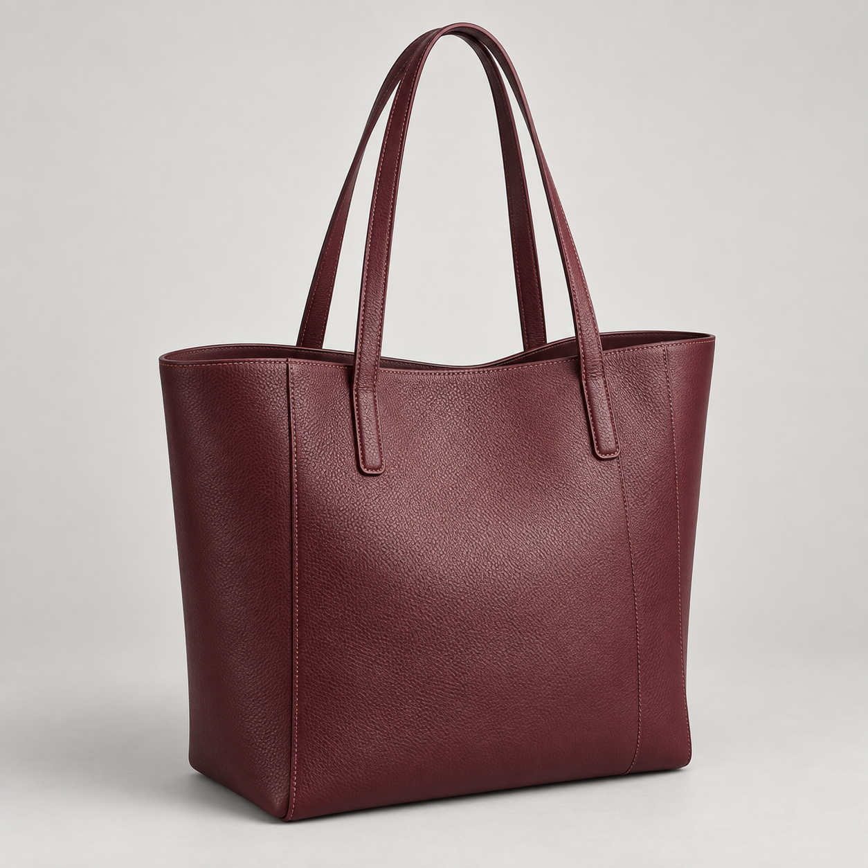 Bordeaux Shopper: Tall open-top shopper silhouette with long double handles and clean vertical seams. Illustrative design reference.
