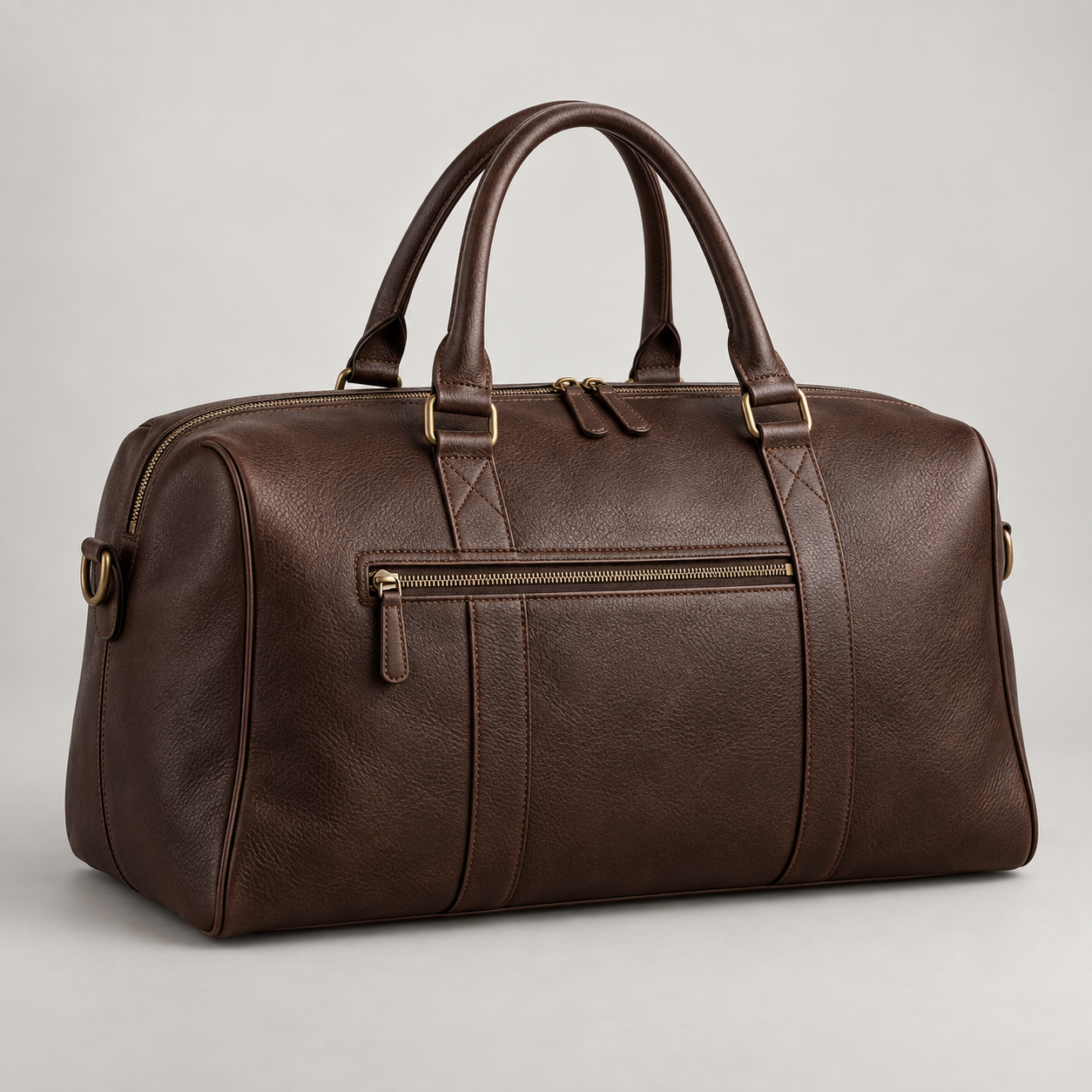 Espresso Overnight: Slim overnight-bag silhouette with double handles and a front zip pocket. Illustrative design reference.