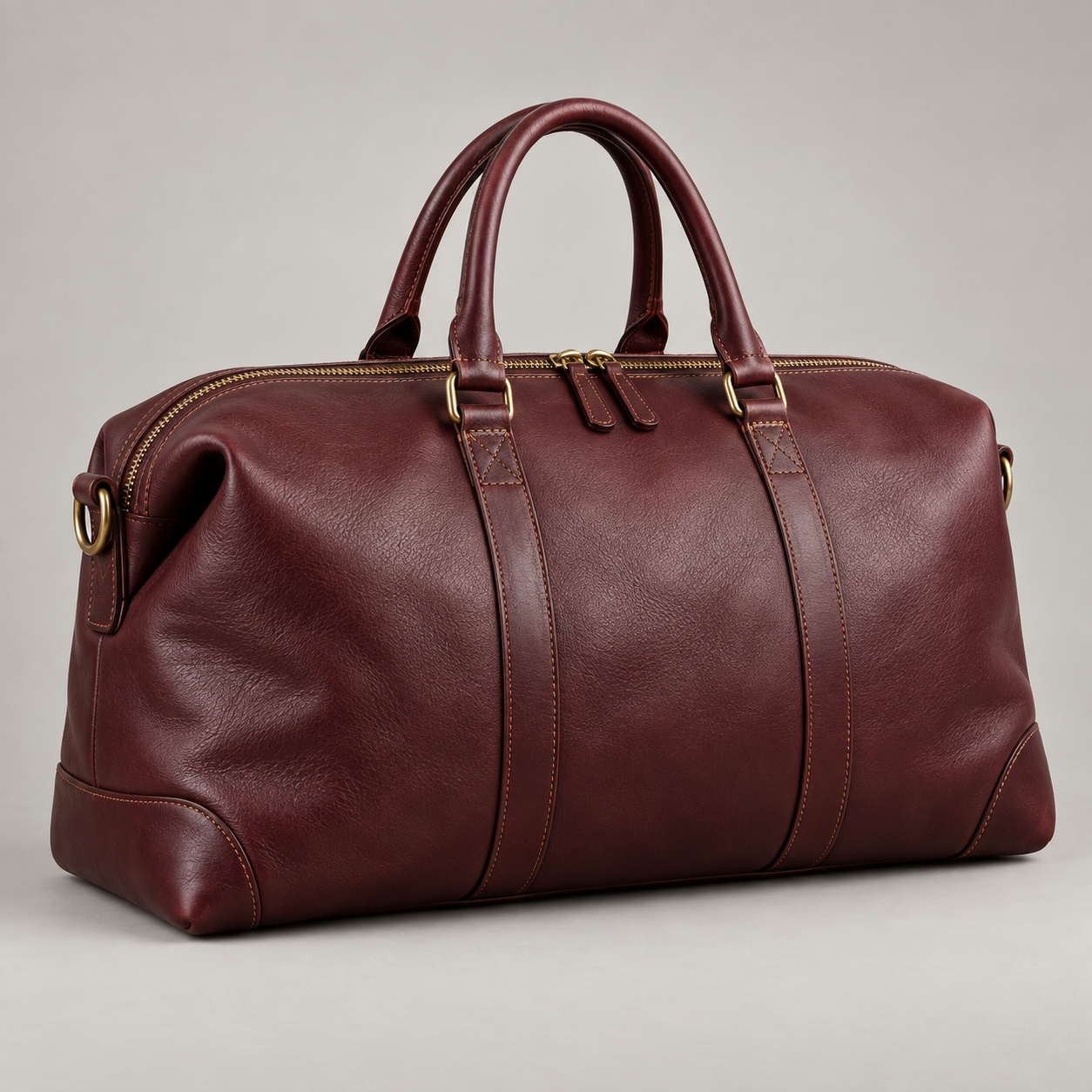 Bordeaux Voyager: Large soft-sided holdall with curved top handles and contrasting brass-tone zips. Illustrative design reference.
