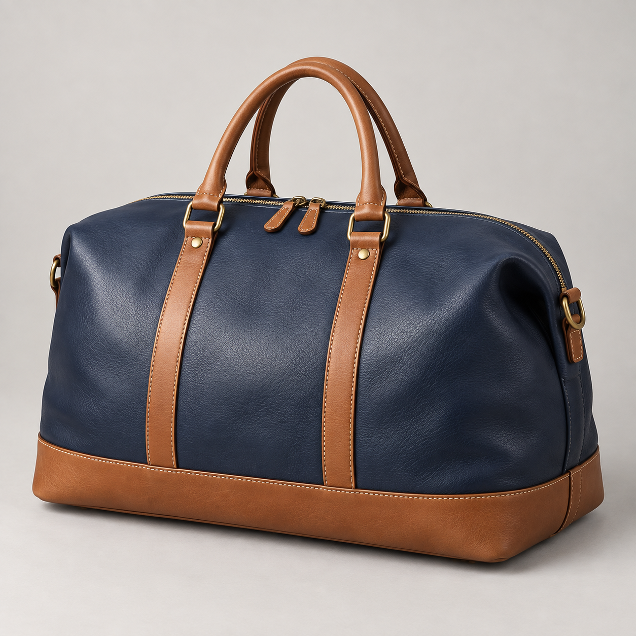Navy Weekender: Rounded weekender silhouette with tan handles and a tan base panel. Illustrative design reference.