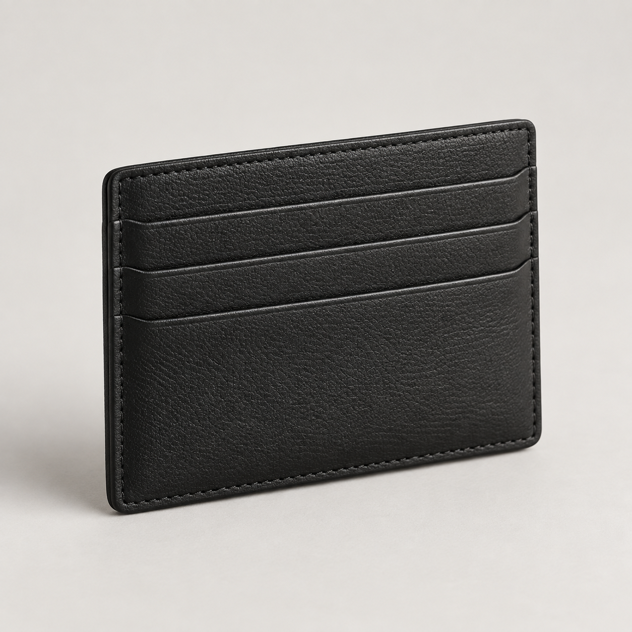 Noir Cardholder: Slim rectangular cardholder with three visible horizontal slots and understated stitching. Illustrative design reference.
