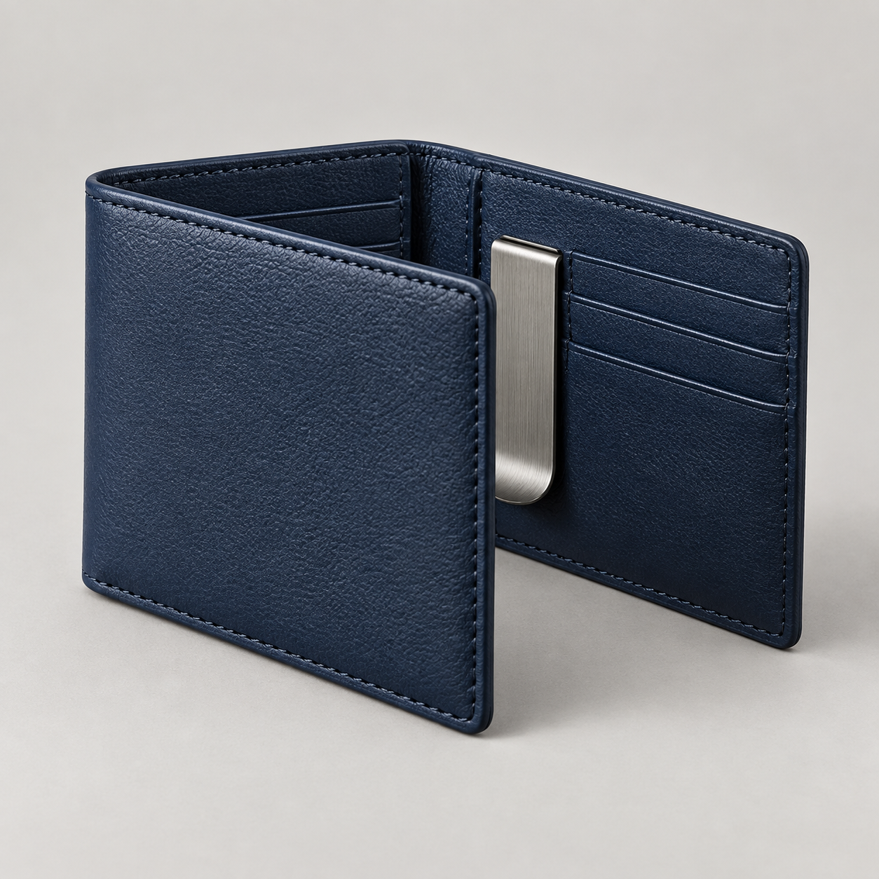 Navy Money Clip: Slim folded wallet shown partly open with a simple brushed metal money clip. Illustrative design reference.